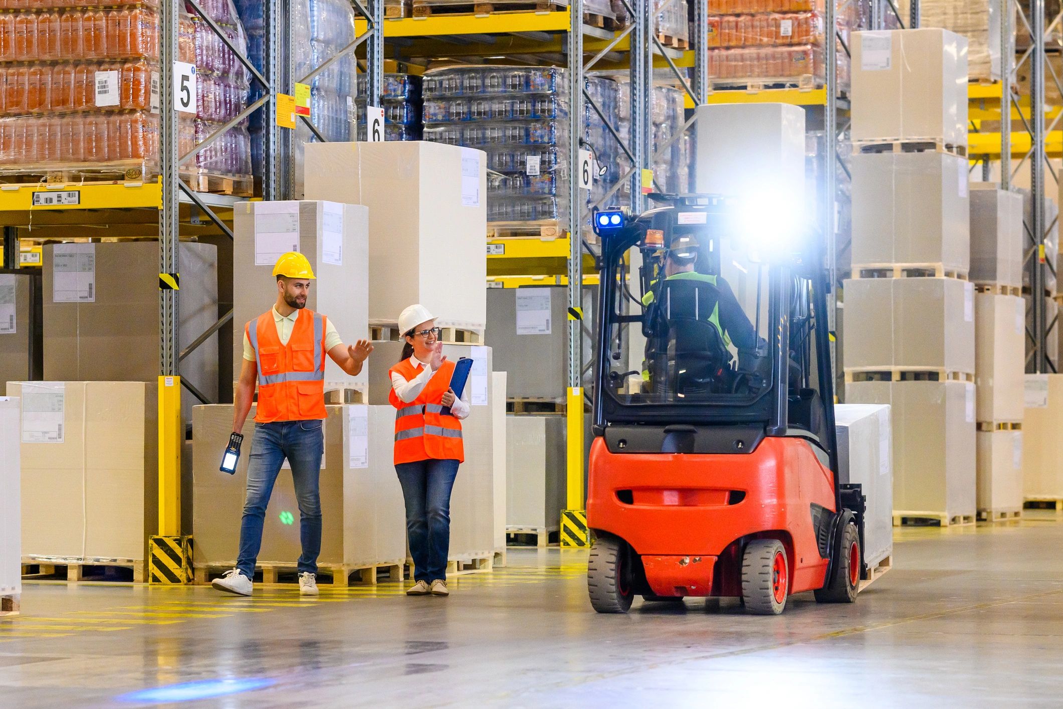 Warehouse logistics team coordinating inventory with forklift